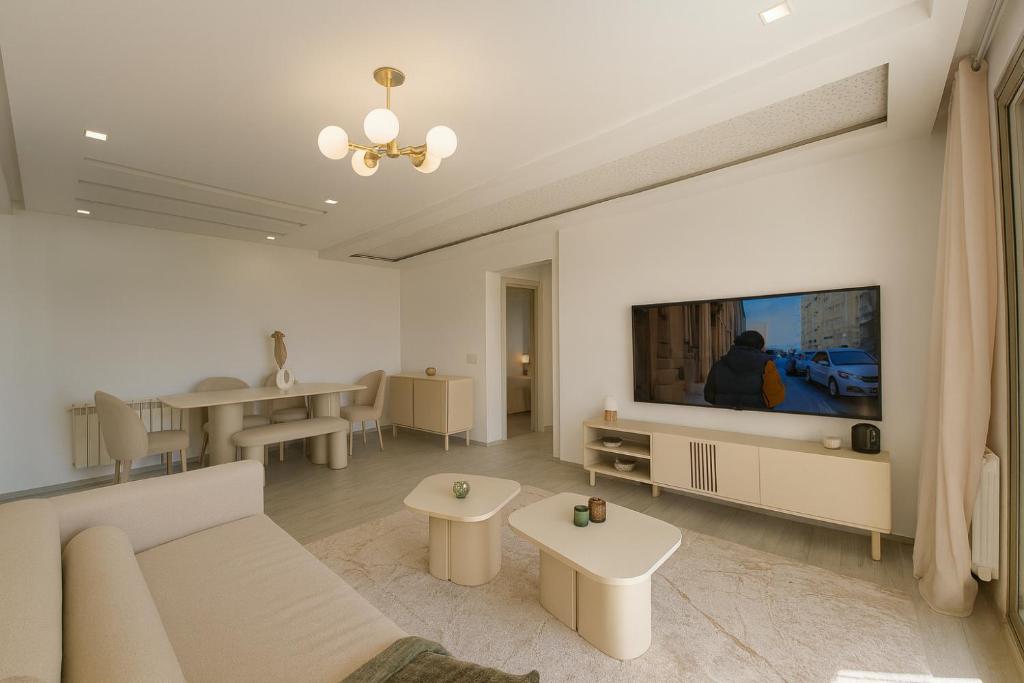 a living room with a couch and a flat screen tv at Luxury 2 Bedroom Apartment Menzah 9C Near the airport in Tunis