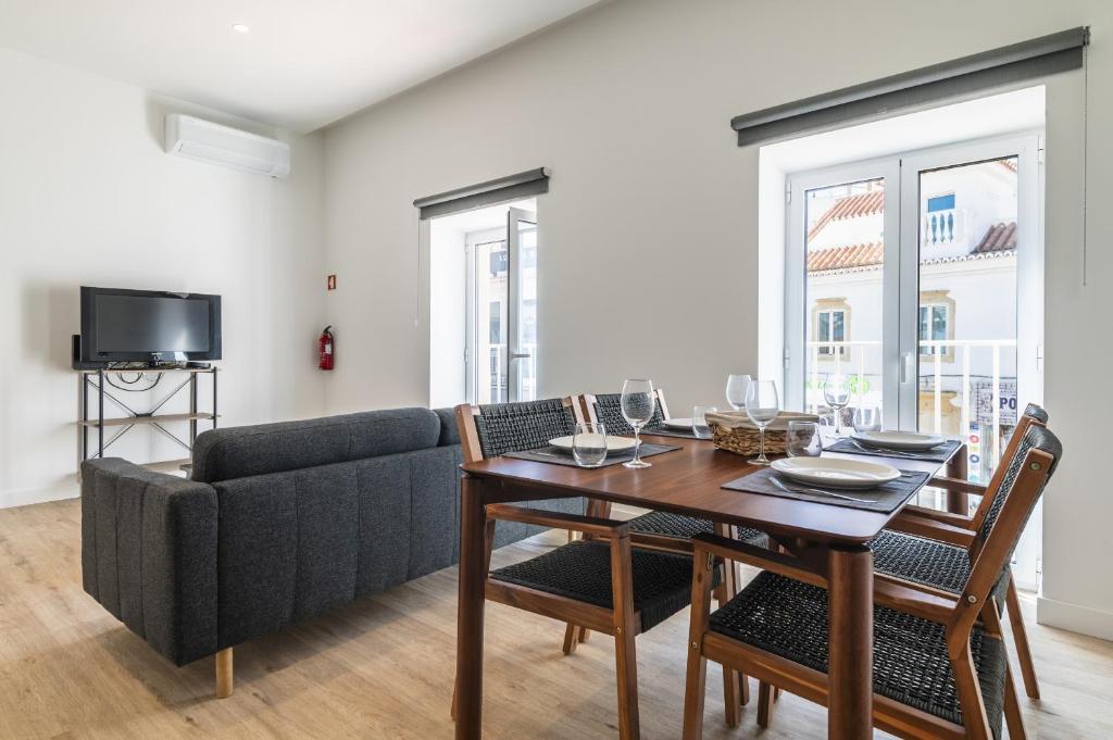 a living room with a table and a couch at Downtown 1 Bedroom Apartment E - 150m from the Beach in Albufeira