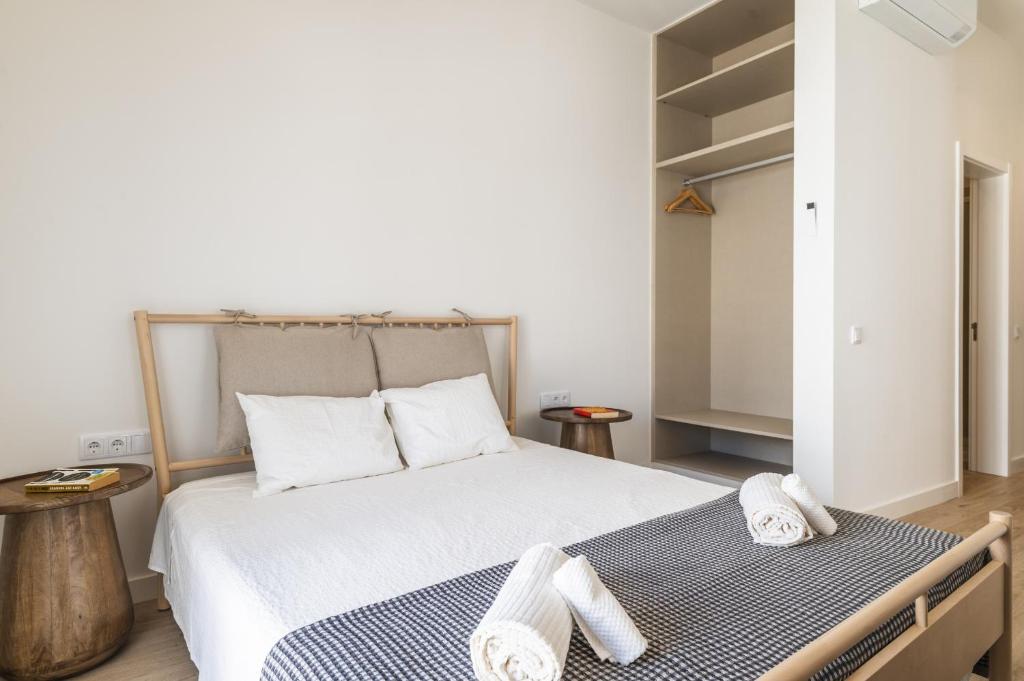 a bedroom with a bed with two towels on it at Downtown Studio Apartment F - 150m from the Beach in Albufeira