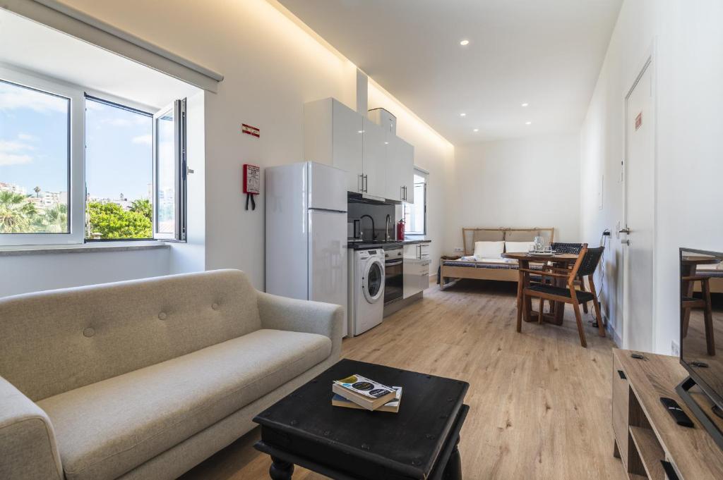 a living room with a couch and a table at Downtown Studio Apartment G - 150m from the Beach in Albufeira