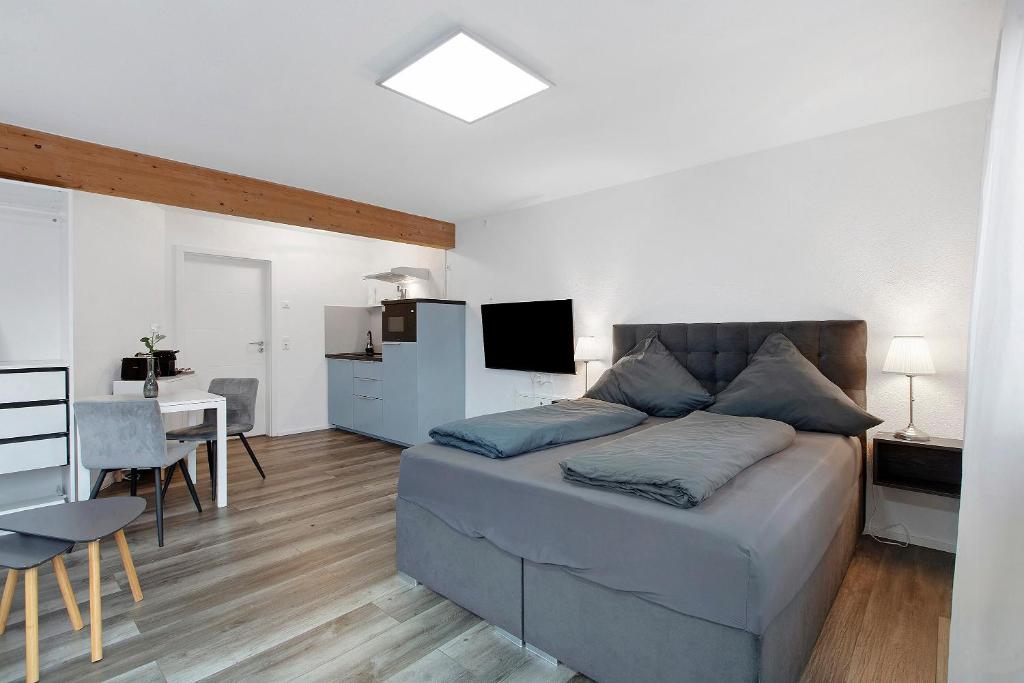a bedroom with a large bed and a kitchen at Motel Ambiente 1 - Luxus Studio in Bad Säckingen