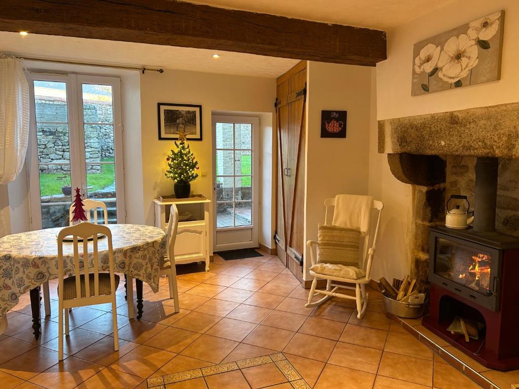 una sala da pranzo con tavolo e camino di Le Cordonnier d'Autrefois - 15 minutes du Puy du Fou a Mortagne-sur-Sèvre