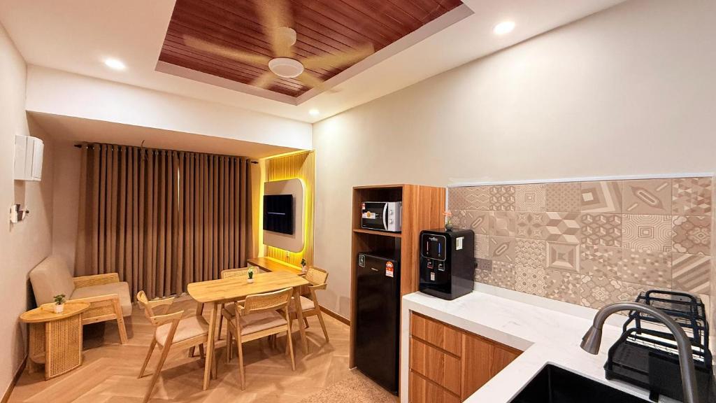 a kitchen with a table and a dining room at Me'Lawwa Studio -Private Pool- in Kampung Padang Masirat