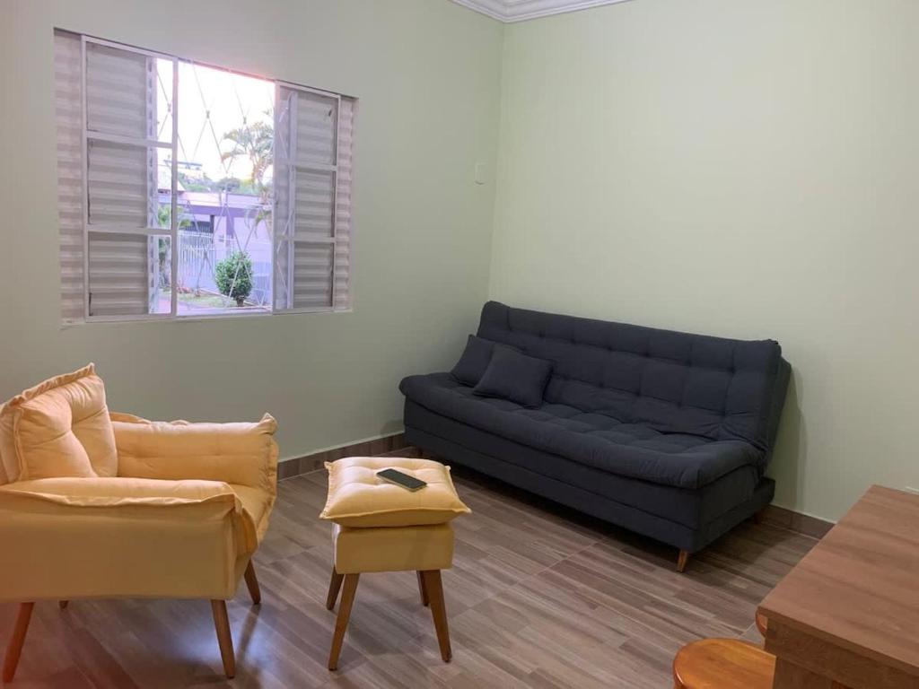 Studio no Centro de Foz Até 6 Hóspedes في فوز دو إيغواسو: غرفة معيشة مع أريكة زرقاء وكرسيين