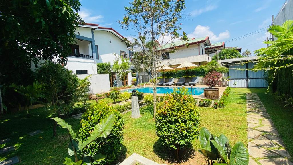 a house with a garden and a swimming pool at Erin Orr Villa in Wadduwa