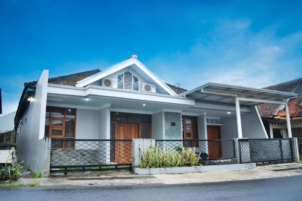 a white house with a fence in front of it at Pondok Sukamanah Tasik in Tasikmalaya