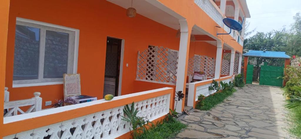 ein orangenes Haus mit einem Weg davor in der Unterkunft Orange apartments in Watamu