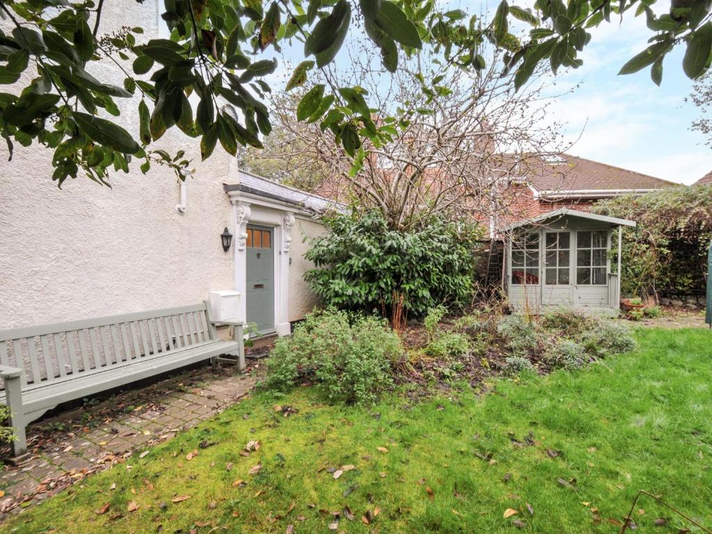 una casa blanca con un banco en un patio en Violet's Rest, en Exeter