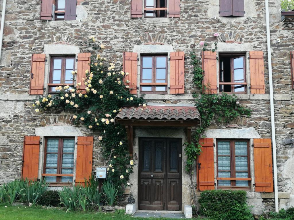 Un edificio con ventanas y una puerta con flores. en O Coeur d'Anaïah, en Laval-sur-Doulon