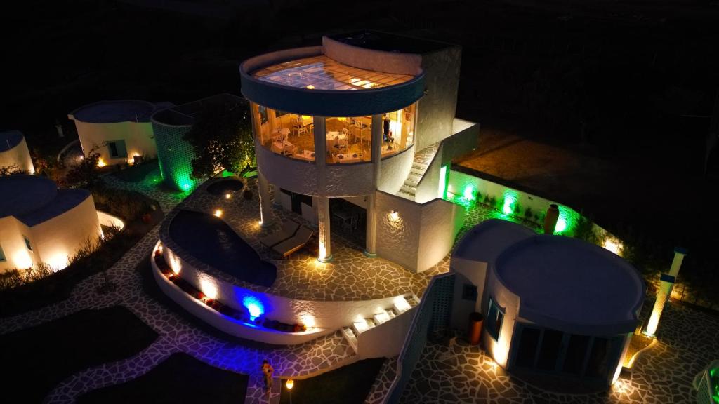 an aerial view of a building with a pool at night at Olymp Spa Boutique Hotel in Monte das Gameleiras