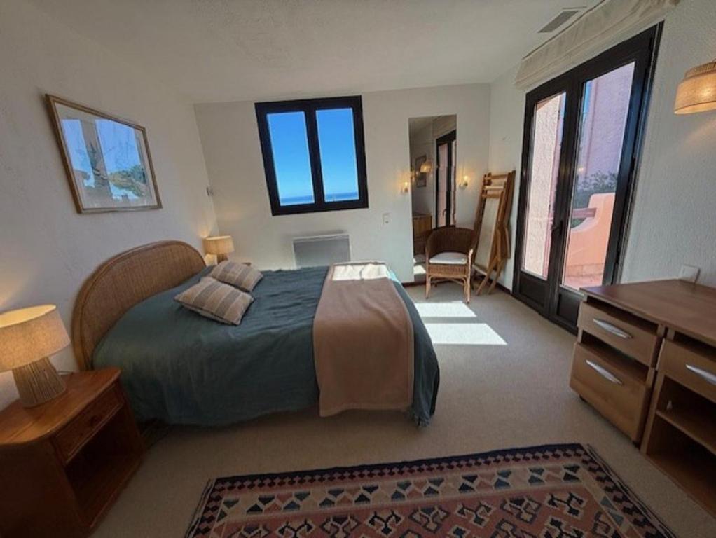 a bedroom with a bed and a dresser and window at 6AMB38 Superbe Villa avec terrasses dans résidence avec piscine commune in Collioure