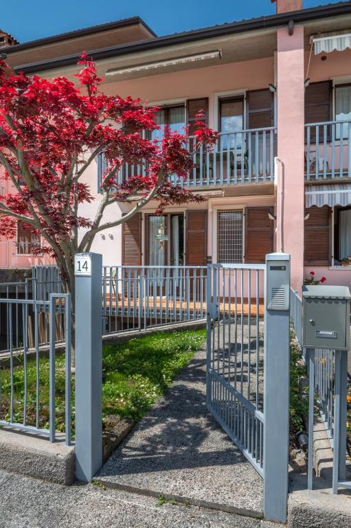 a fence in front of a house with red flowers at WANDERLUST VILLETTE a SCHIERA - Bardolino, Lago di Garda - Verona in Bardolino