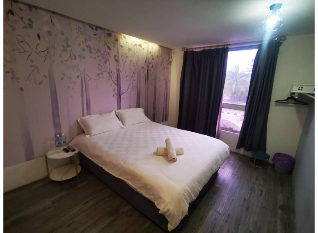 a bedroom with a bed with a teddy bear on it at Hotel O ZZZ in Kuah