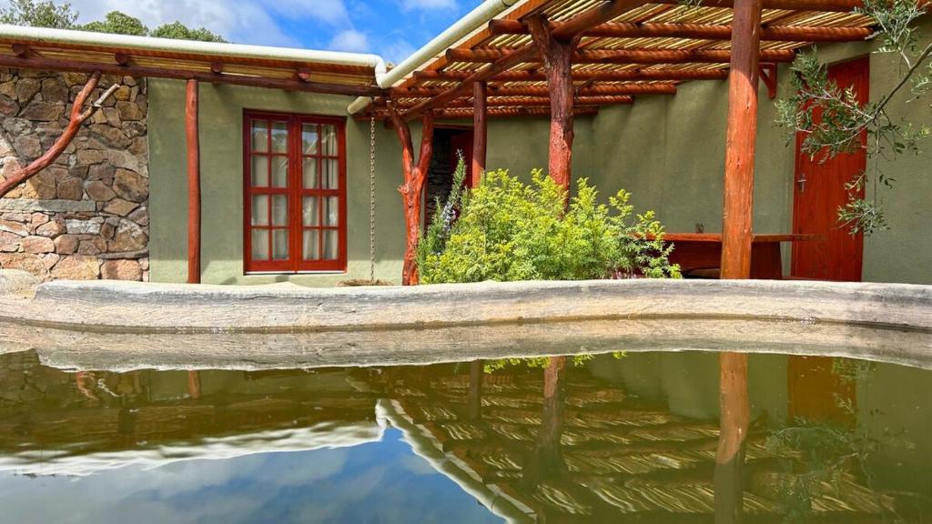 Casa Gaucho hospedate en una reserva natural في Aiguá: منزل فيه انعكاس في تجمع المياه