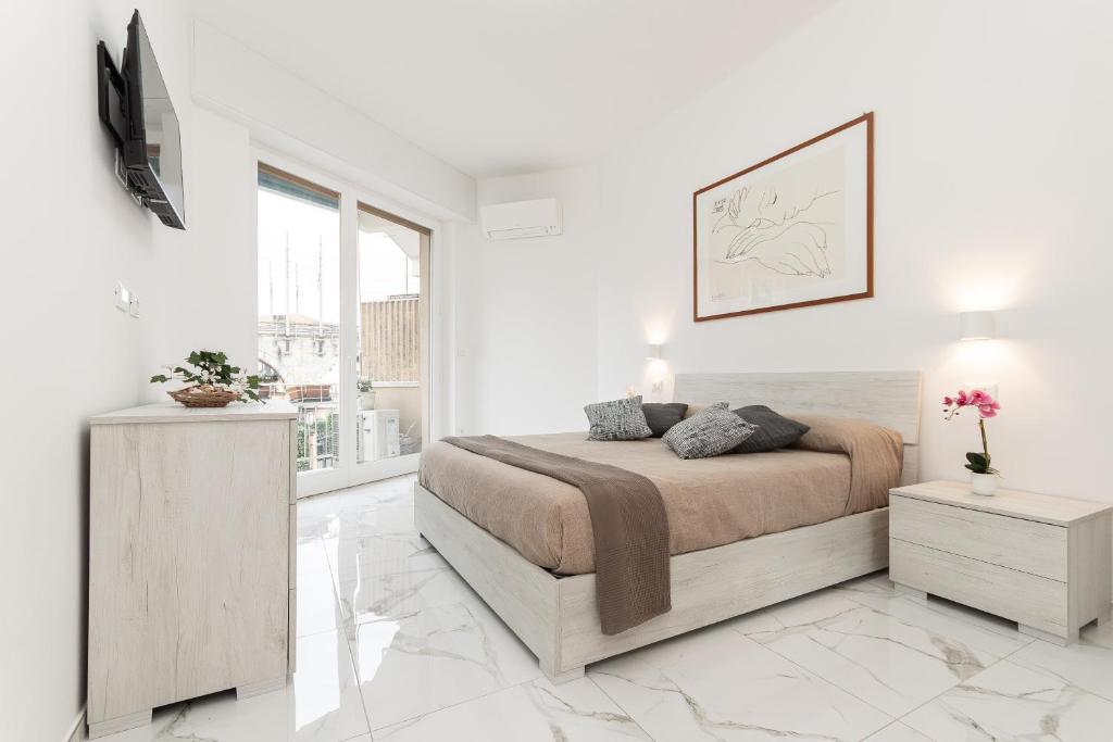 a white bedroom with a bed and a tv at Il Sogno a due passi dal mare vicino PORTOFINO in Rapallo