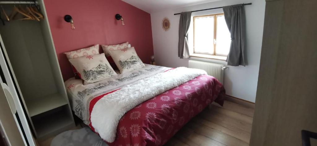 Schlafzimmer mit einem Bett mit roten Wänden und einem Fenster in der Unterkunft Le Ranch Des Ours in Champagnac-la-Rivière