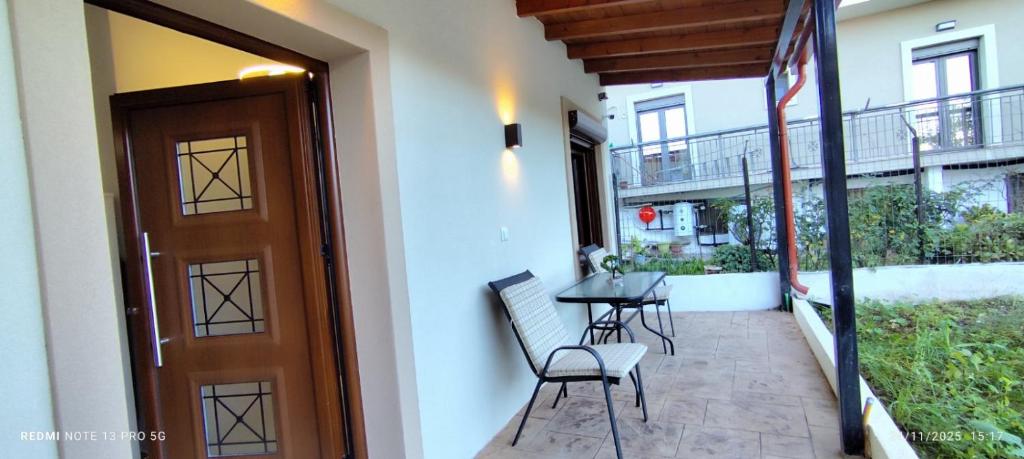 a balcony with a table and chairs next to a door at Αγιονέρι in Mouzaki