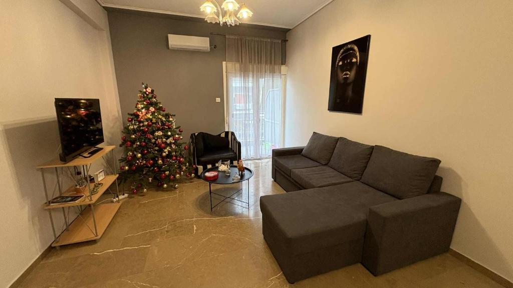 a living room with a christmas tree and a couch at MARIAS APARTMENT TRIKALa in Tríkala