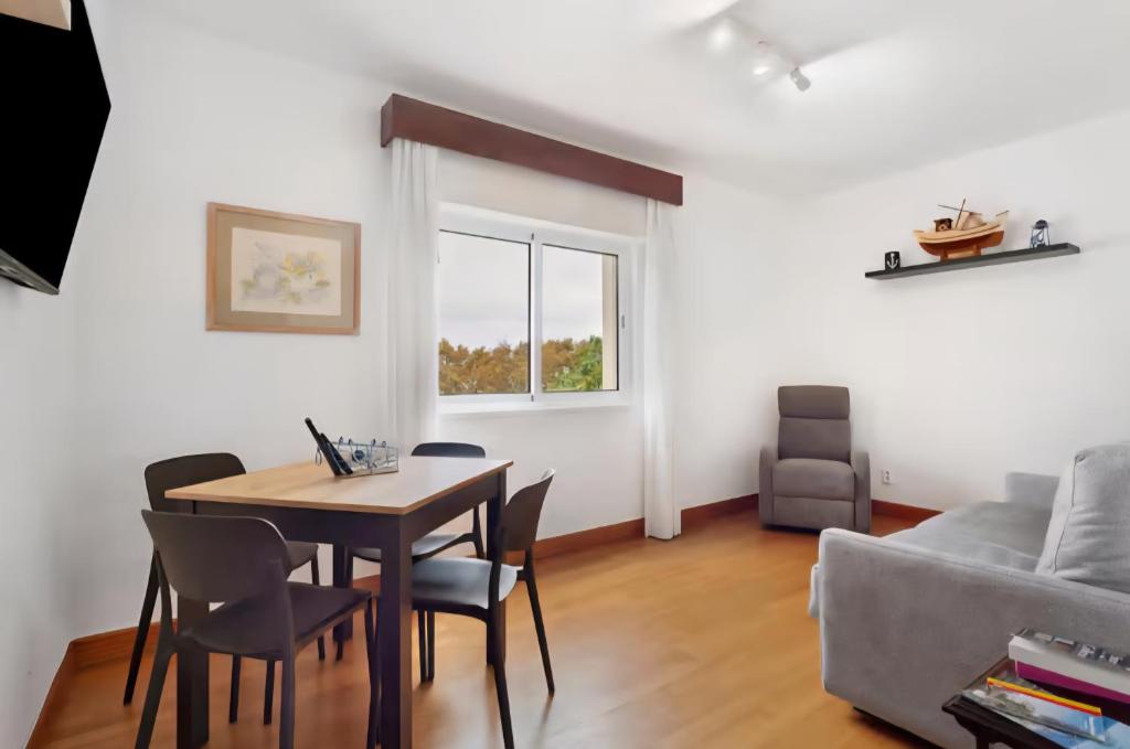 een woonkamer met een tafel, stoelen en een bank bij Machico Bay in Machico