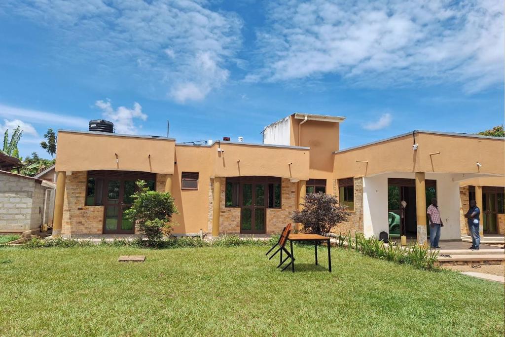 una casa con una mesa delante en Nilevic Guest House Entebbe, en Entebbe
