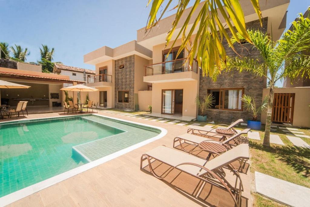 Casa nova em condominio com 4 suites spa e academia في بورتو سيغورو: فيلا بمسبح واثاث الباحة