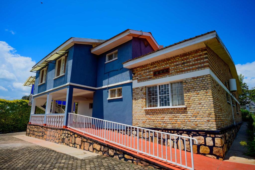 GahondoQuality Inn Motel, Nyanza的一栋蓝色的房子，带一个红色的阳台。