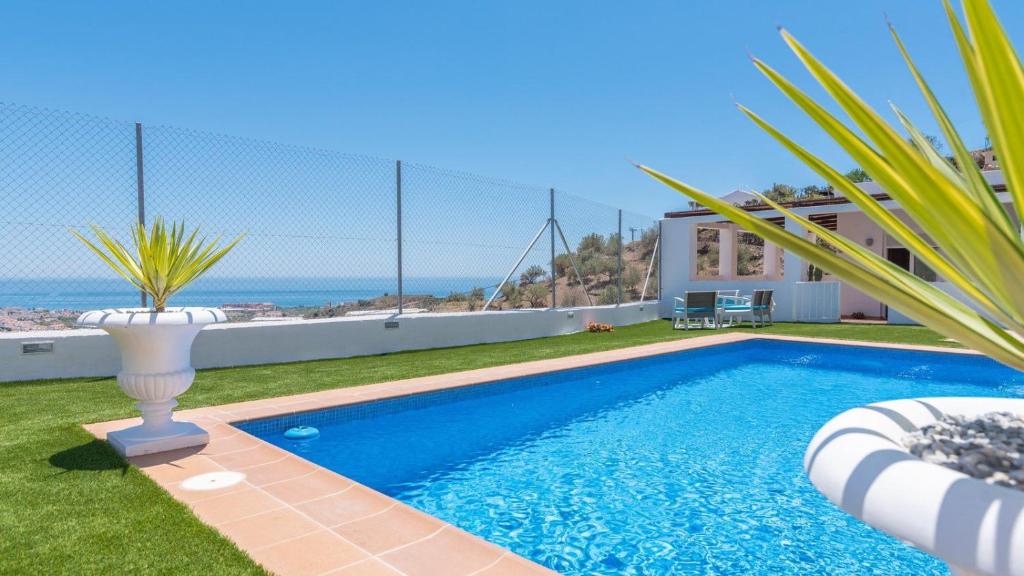 ein Swimmingpool in einem Hof mit Blick auf das Meer in der Unterkunft Villa Diego Torrox by Ruralidays in Torrox