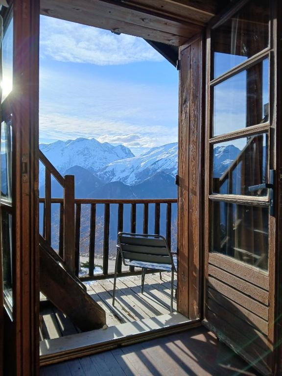 a chair sitting on a balcony with a view of mountains at Demeure Sauvage - Étage 1 in Villard-Reculas