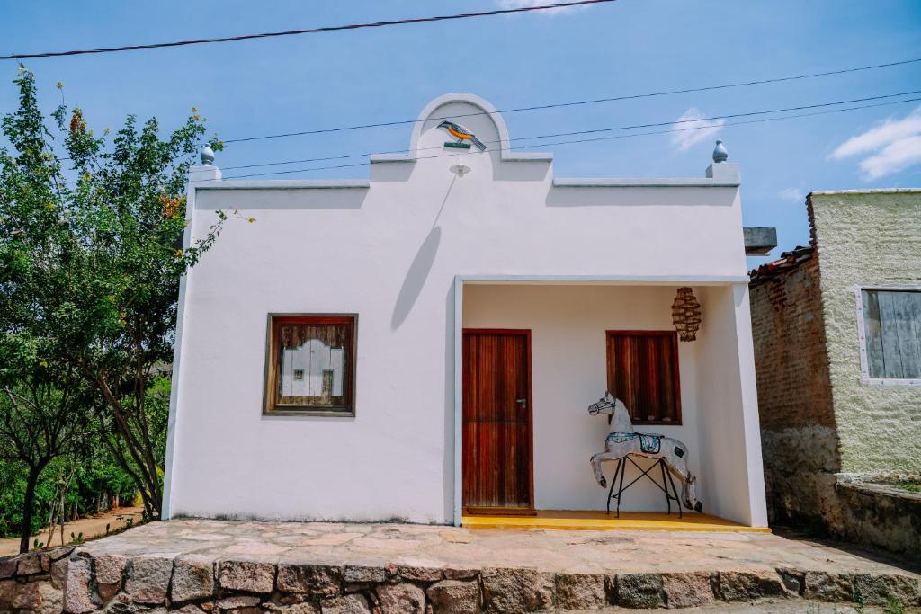 una casa bianca con una porta rossa di Casa Sibite - Ilha do Ferro a Pão de Açúcar