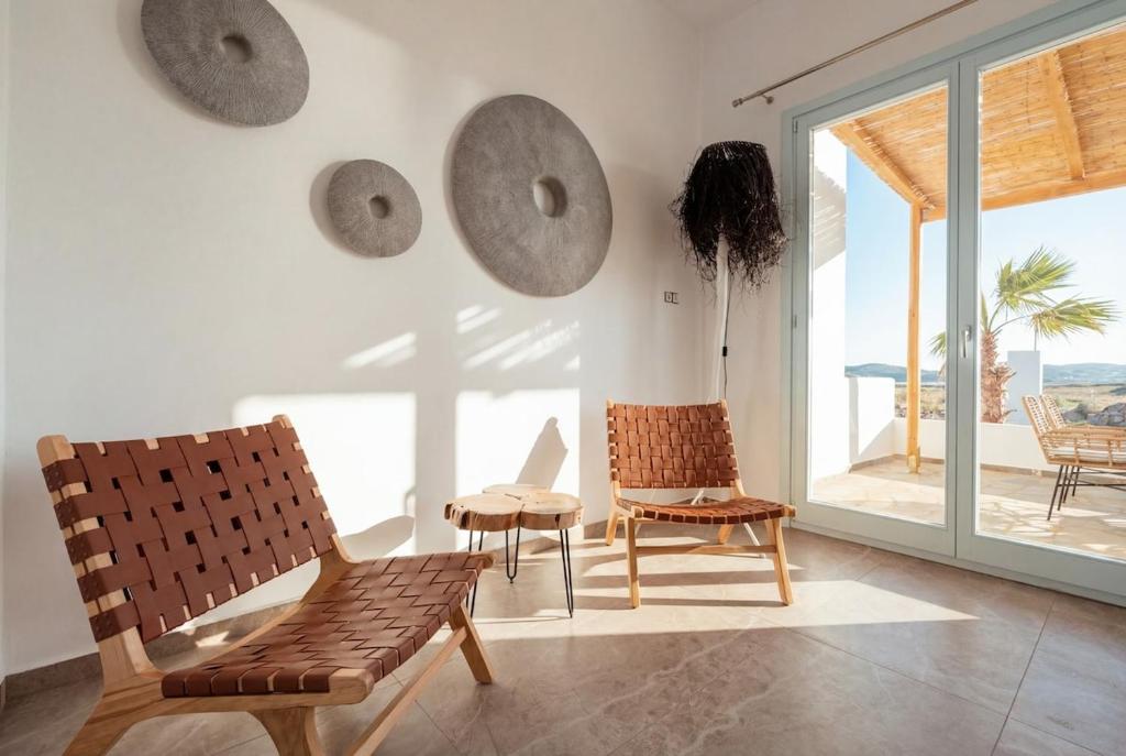 a living room with chairs and a large window at Kyma Paros Apartments 1 
