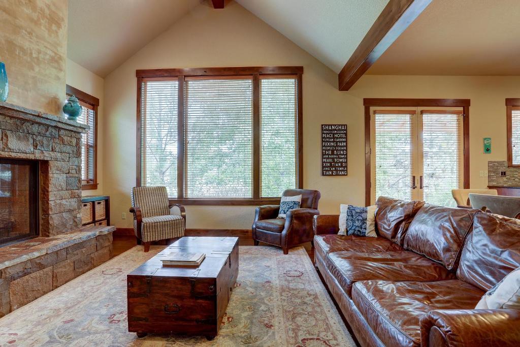 un soggiorno con divano in pelle e camino di Points West a Deschutes River Woods