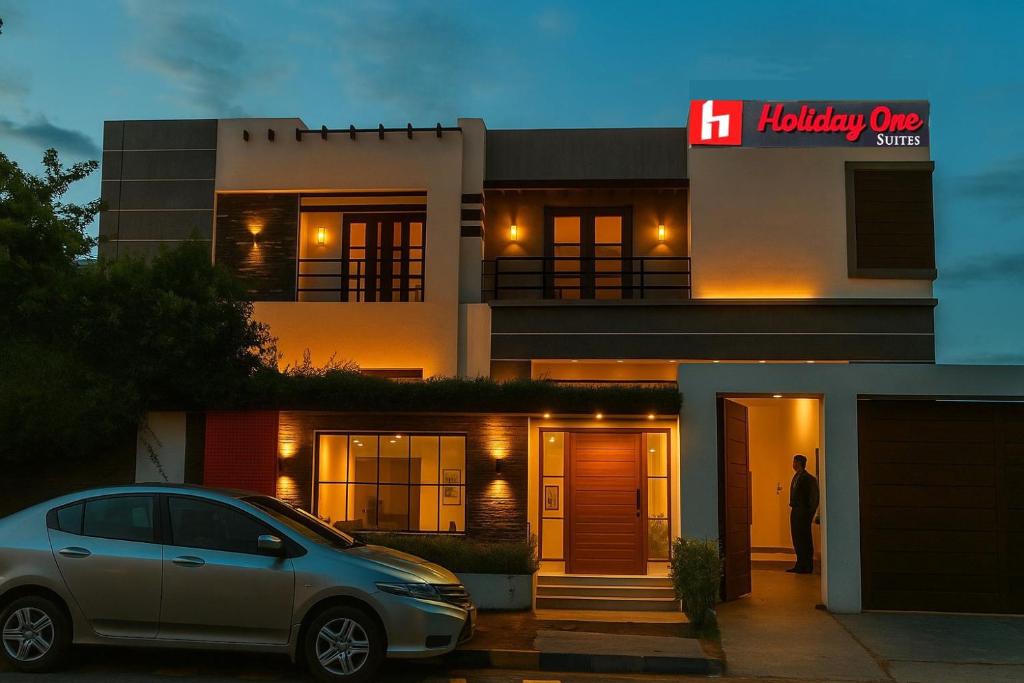 卡拉奇Holiday One Hotel & Suites的停在房子前面的银色汽车