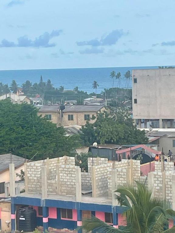 eine Gruppe von Gebäuden mit dem Meer im Hintergrund in der Unterkunft Regal Royal Suites in Kokrobite