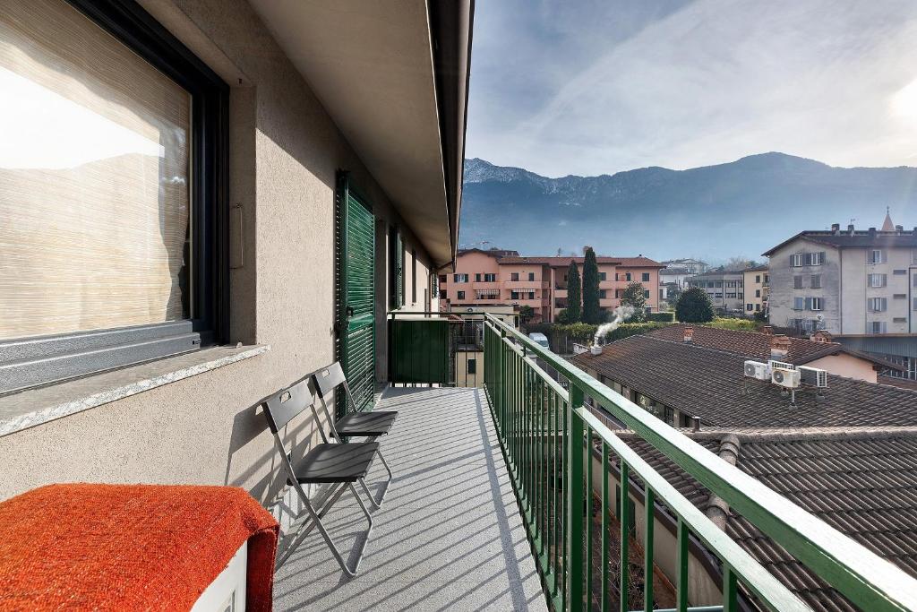 a balcony with two chairs and a view of a city at La dimora del Lago in Colico