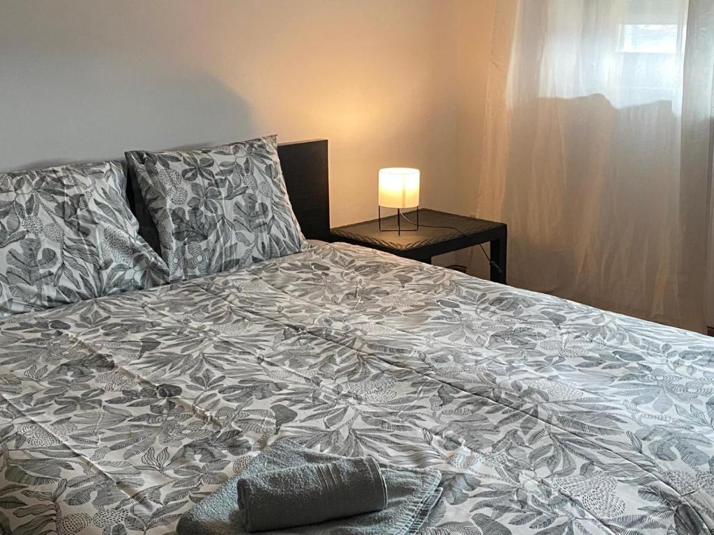 een groot bed in een slaapkamer met een lamp op een tafel bij Valença RoofTop by Beeflats BnB in Valença