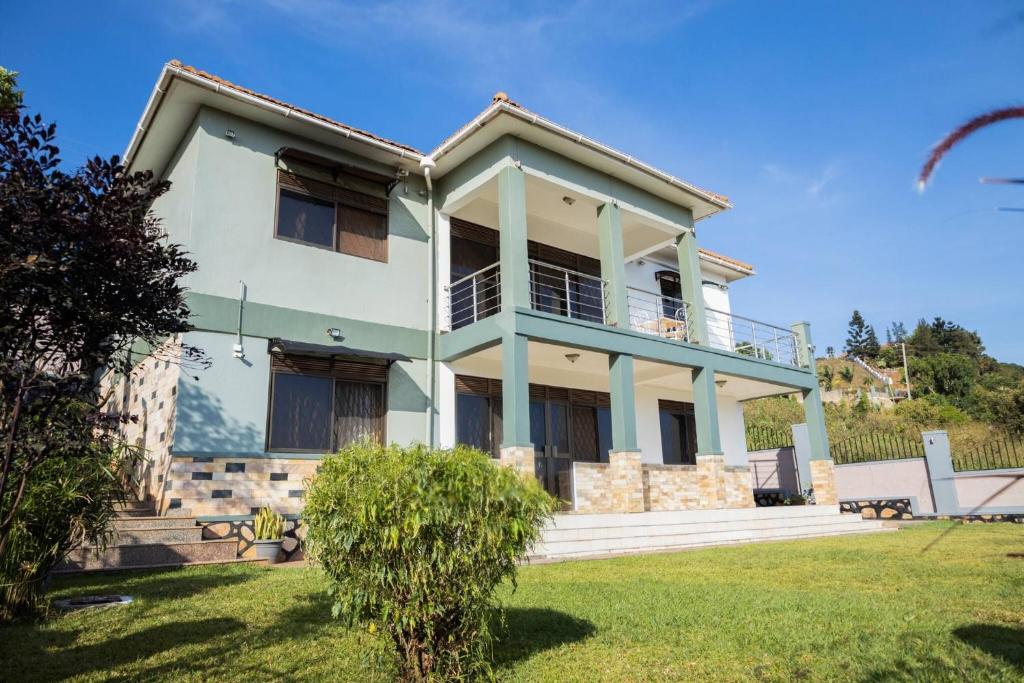 Green Valley Palace A quiet Happy Place to stay في Namulanda: منزل أبيض كبير مع ساحة كبيرة