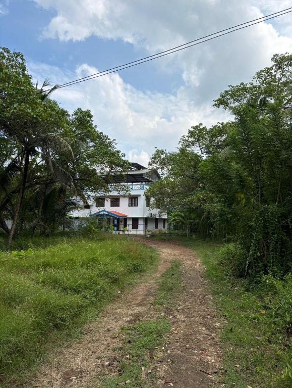 a dirt road in front of a house at Thiramizhi in Cochin