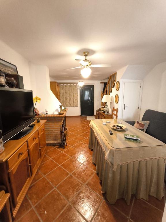 una sala de estar con un televisor y una mesa en La Casita de Marisol, en El Real de la Jara
