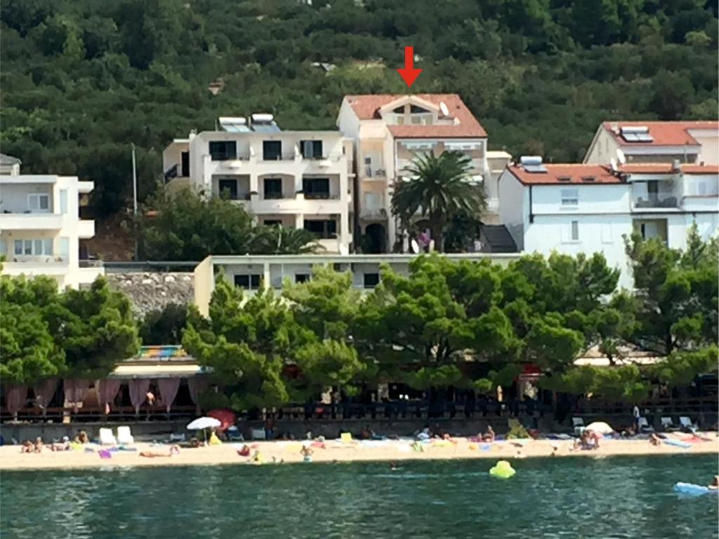 a beach with a group of people in the water at Villa Nora in Tučepi