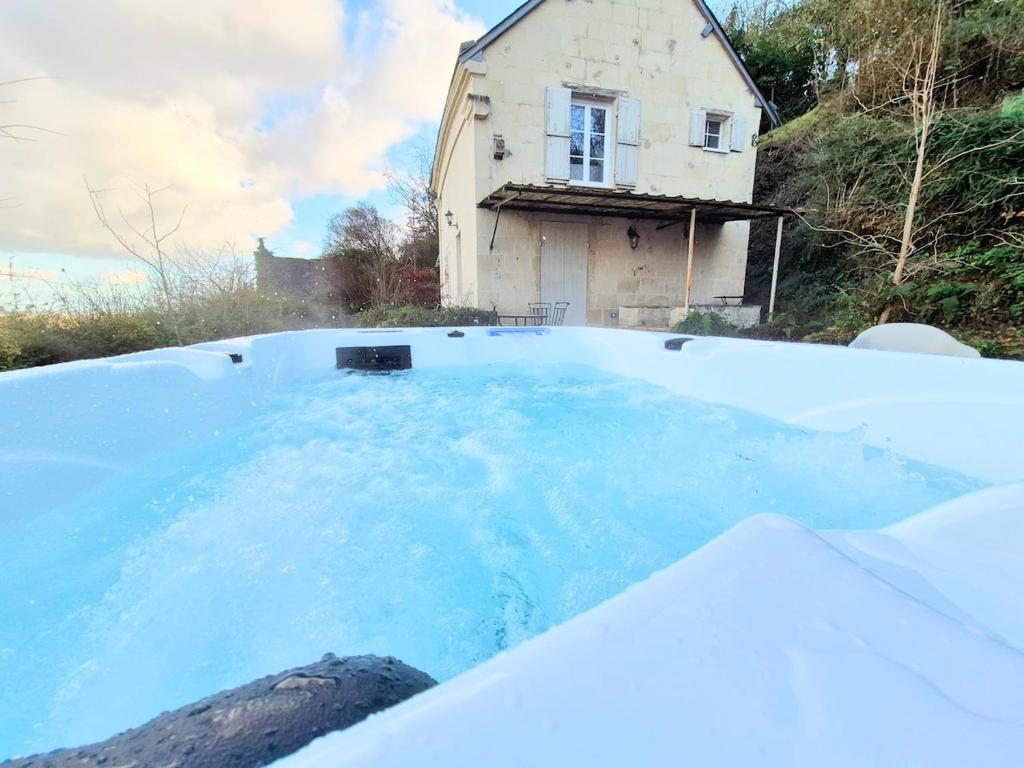 ein Pool mit blauem Wasser vor einem Haus in der Unterkunft Villa Margaux in Saint-Germain-sur-Vienne