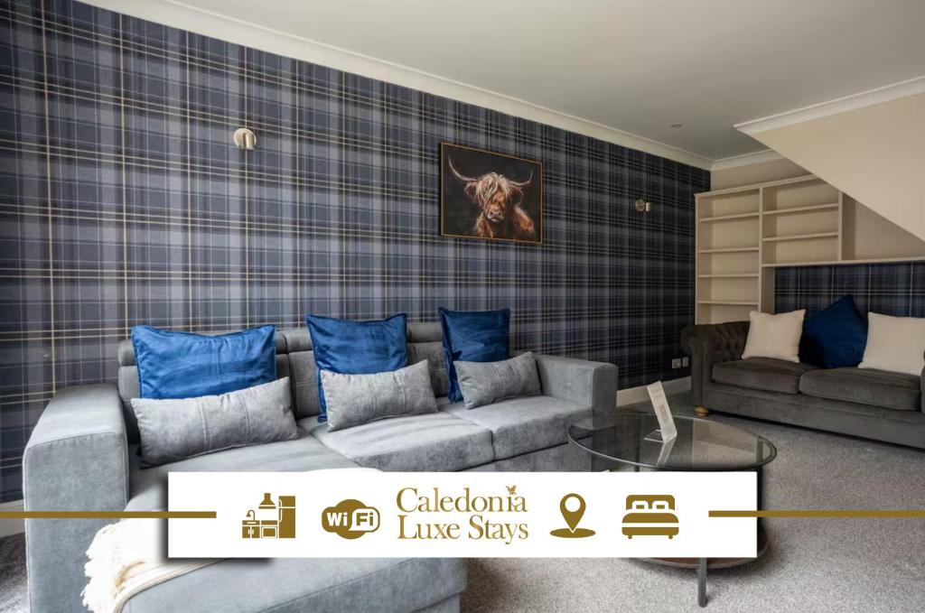 ein Wohnzimmer mit Sofa und blauen Kissen in der Unterkunft The Rise Retreat in Livingston