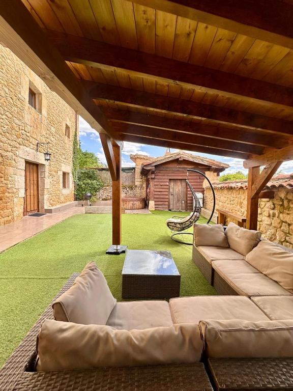 an outdoor living room with a couch and a table at CASA RURAL PALACIO LOS LABREQUINES in Villacomparada de Rueda