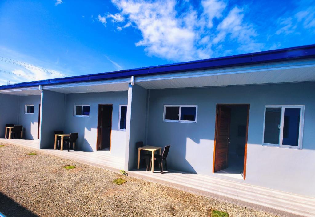a blue and white house with chairs and tables at Casanuestra Apartelle in Panglao