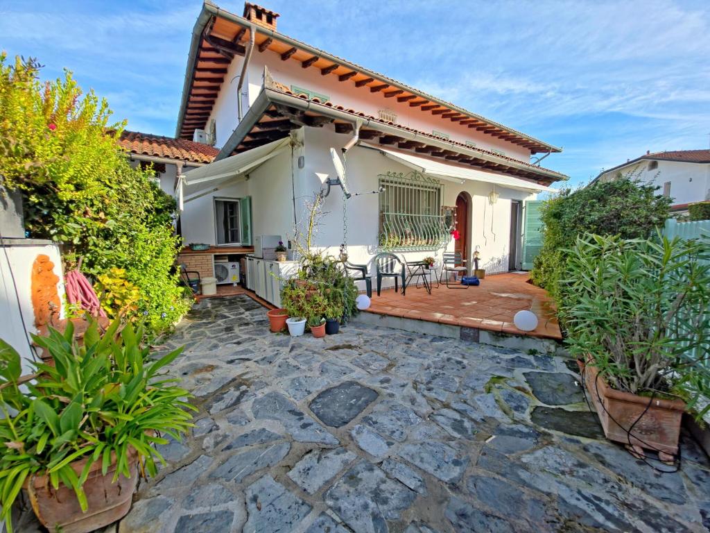 eine Terrasse eines weißen Hauses mit Pflanzen in der Unterkunft I Cipressi in Cinquale