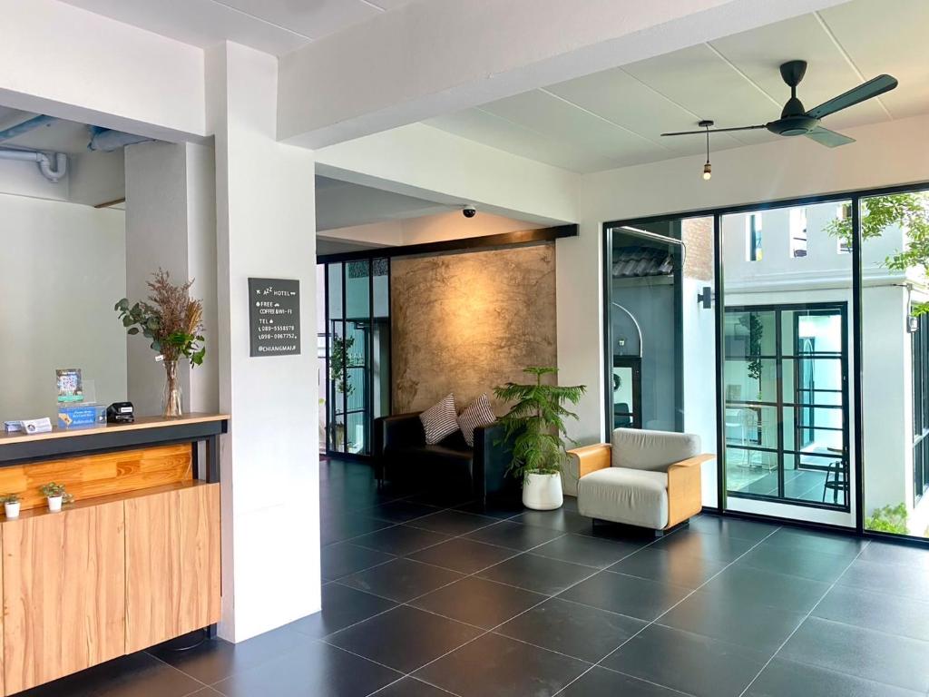 A bright hotel lounge with a ceiling fan, armchair and reception counter.