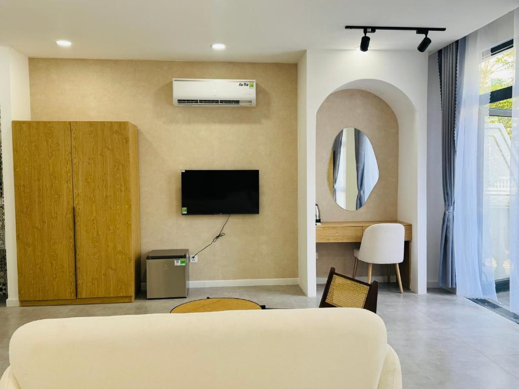 Una sala de estar con un sofá y un televisor en la pared. en StayLa Homestay, en Phu Quoc
