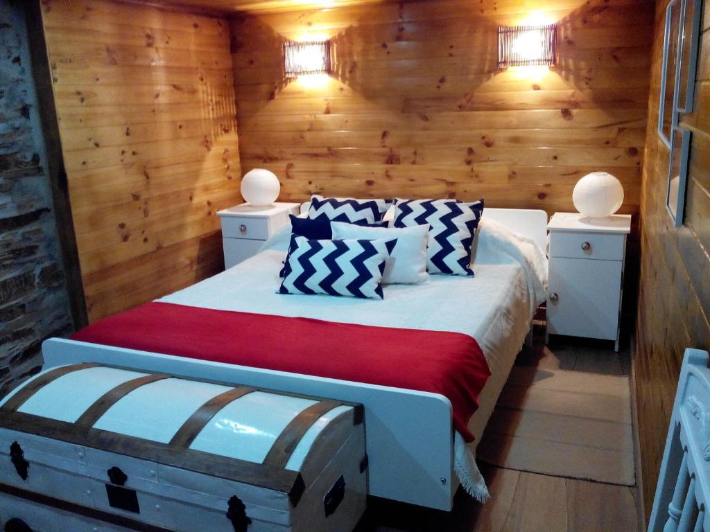 een slaapkamer met een bed in een houten hut bij Casa do Terreiro in Pardieiros