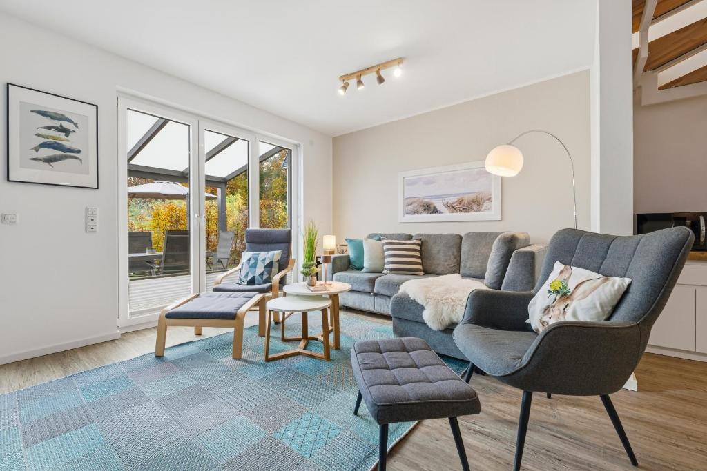 een woonkamer met een bank en twee stoelen bij Bernsteinquartier BQ 6e in Kolpinsee