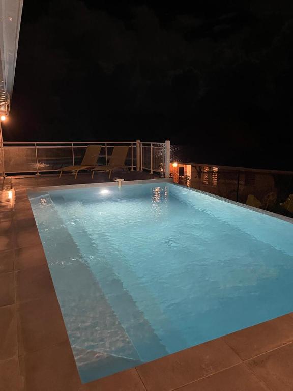 a large swimming pool at night with chairs in it at Villa Outaouais T4 in Bielle
