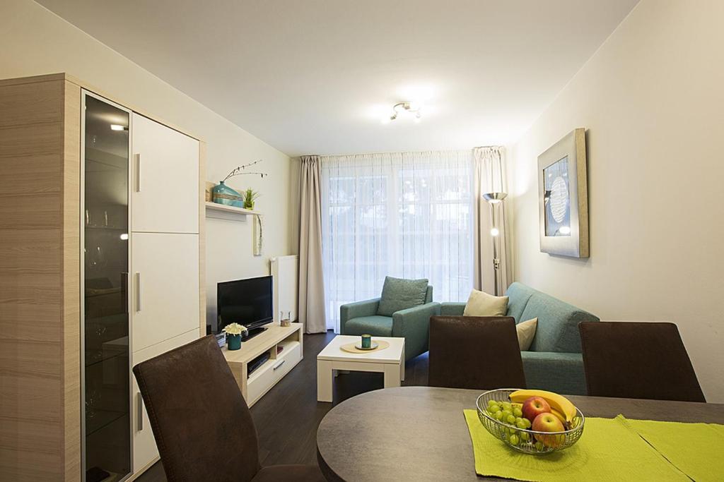 a living room with a couch and a table with a bowl of fruit at Residenz am Balmer See - BS 05 mit Wellnessbereich in Balm